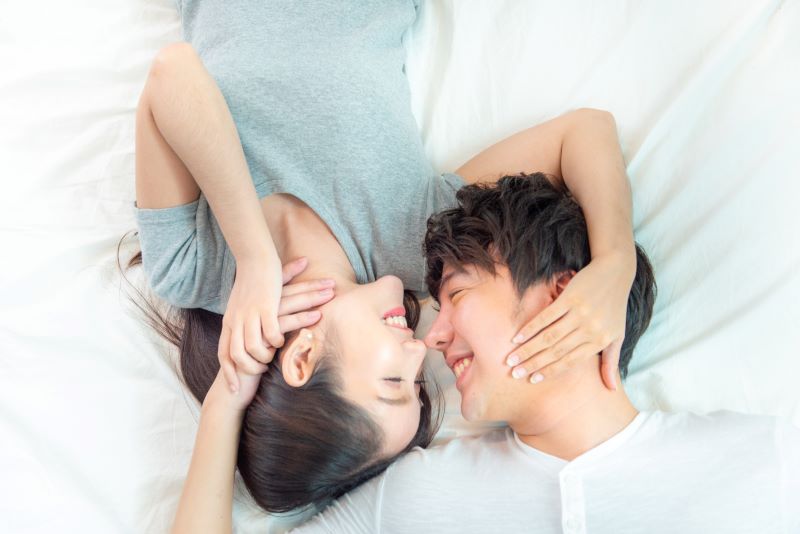 close up portrait pretty young asian couple with happiness asia man woman lay bed facing together with big smile hand touch face love emotion with valentine concept s