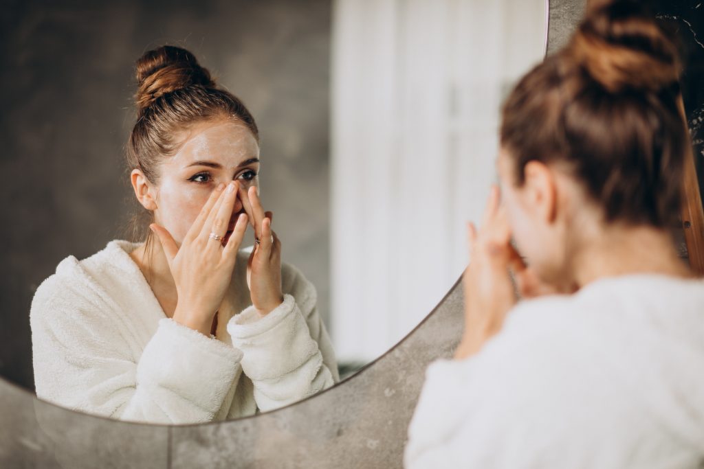 woman home applying cream mask