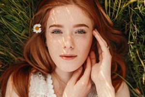 beautiful positive tranquil ginger teen girl lying grass