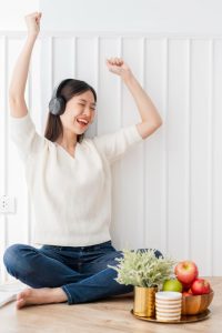 vacation moment with beautiful asian woman enjoy listening music headphone with peaceful happiness white room interior background