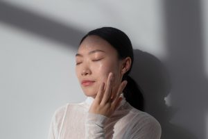 beautiful asian woman posing with facial cream