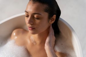young woman relaxing taking bath bathtub filled with water foam