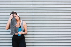 athletic woman wiping face after workout