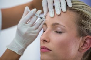 female patient receiving botox injection forehead