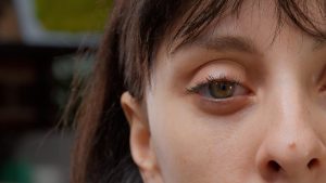 macro shot one green eye half face front camera authentic beautiful woman smiling happy attractive adult with healthy vision eyeball with eyelashes eyebrow close up