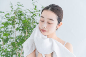 asian japanese young woman dressing face with white bath towel