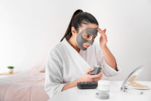 woman applying clay face mask side view