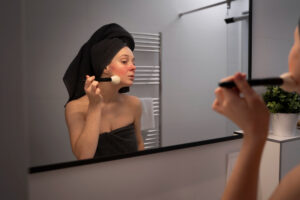 woman dealing with rosacea applying make up with brush