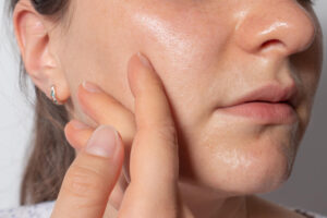 woman puts oil skin massages face