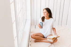 woman with mug book enjoying sunlight