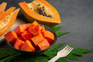 fresh papaya cut into pieces put black plate