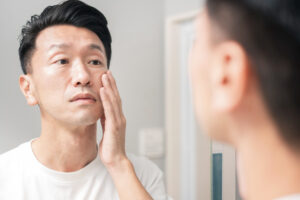 man who looks mirror checks condition his skin