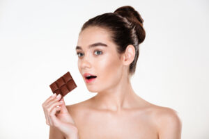 portrait hungry half naked woman with dark hair eating chocolate bar being diet