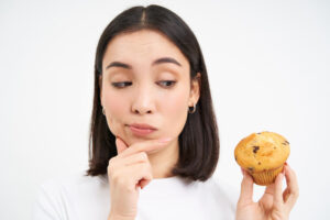 portrait young woman holding apple against white background