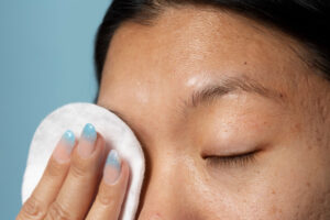 side view woman using cotton pad