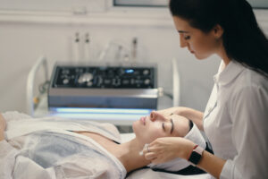 female cosmetologist making facial treatment beautiful woma